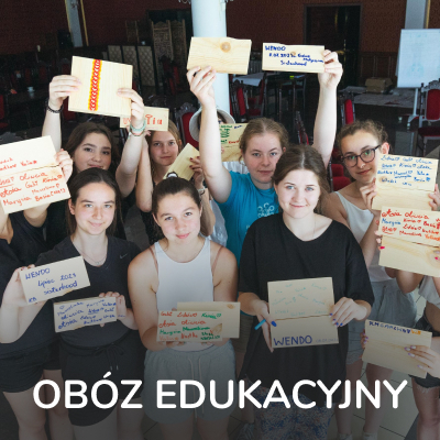 Grupa uczestników trzymających tabliczki na obozie edukacyjnym „Polsko-Ukraińskie Siostrzeństwo”.